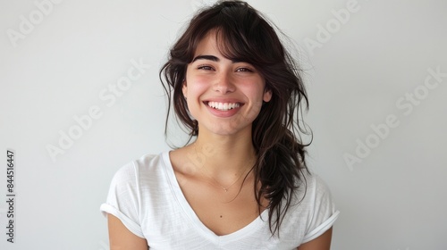 Smiling European American 28 year old black hair, dark brown eyes, white v-neck t-shirt model, white background photoshoot, professional photo studio setting photo