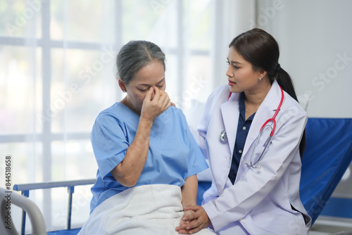 Vászonkép A healthcare professional comforts a distressed elderly patient, offering emotional support in a hospital setting