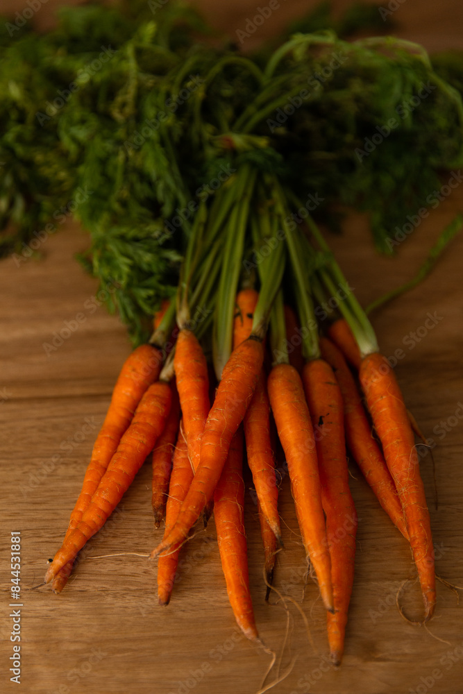 low key photo of a bunch of orange carrots on a wooden board low key photo of a bunch of orange carrots on a wooden board