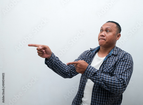 Adult Asian man shocked gesture with his right hand pointing to the side photo