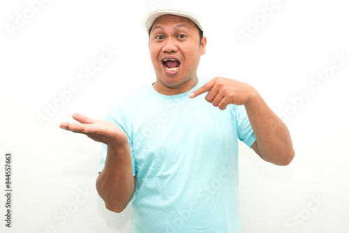 Attractive Asian man smiling while pointing to his open hand palm photo