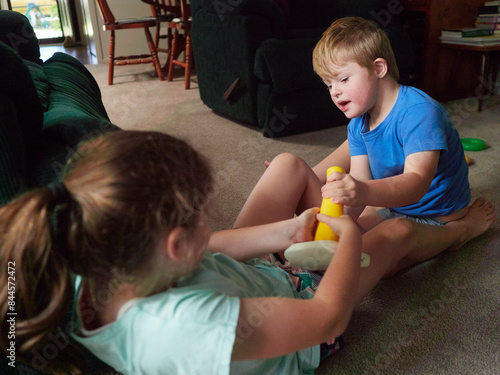 Blonde Boy Playing on Floor fighting over toy with Sister