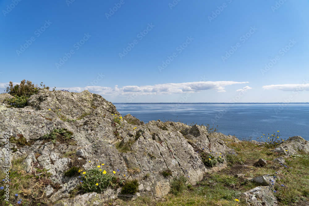 Des rochers face à la mer d'Iroise : un panorama saisissant où les formations rocheuses se dressent fièrement contre les vagues puissantes et les eaux bleues profondes.