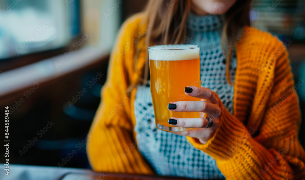 Cheers to Good Times: A Woman Holding a Glass of Beer at the Bar, Enjoying Relaxation and Socializing in a Lively Atmosphere. Cheers to Good Times: A Woman Holding a Glass of Beer at the Bar, Enjoying Relaxation and Socializing in a Lively Atmosphere.