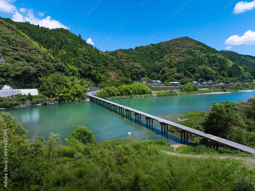 Fototapeta premium ドローン空撮。初夏、快晴の名越屋沈下橋と仁淀ブルー。高知県吾川郡いの町