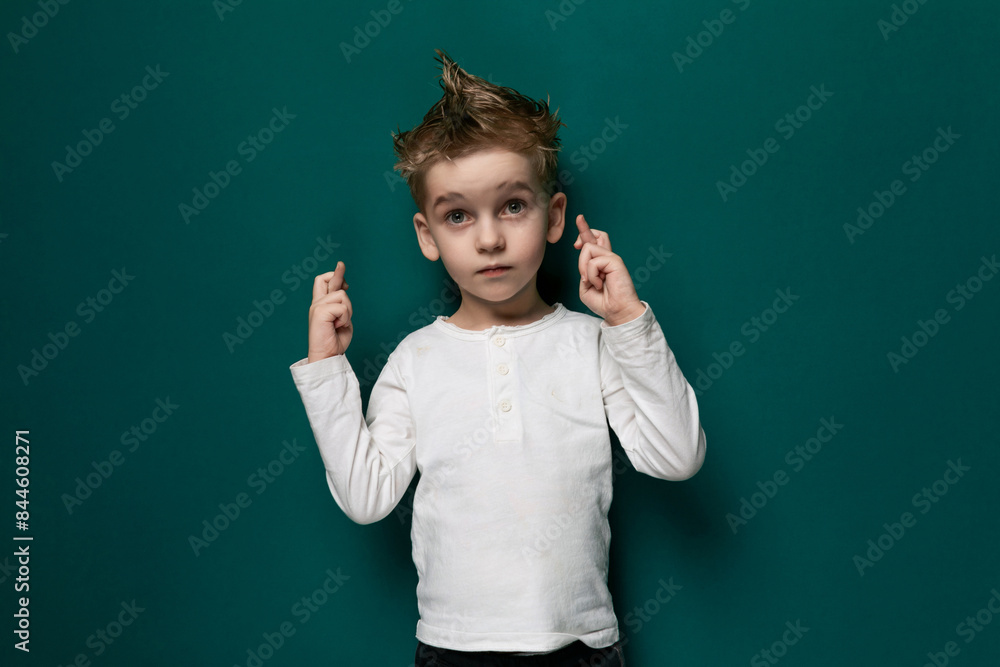Young Boy With Messy Haircut Standing in Front of Green Wall Young Boy With Messy Haircut Standing in Front of Green Wall