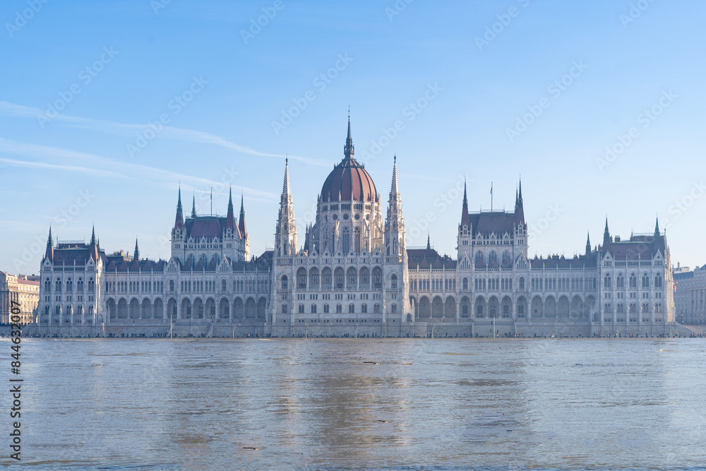 Fototapeta premium The neo-Gothic building of the Hungarian legislature, the Parliament with the river Danube flooding the quays in the foreground