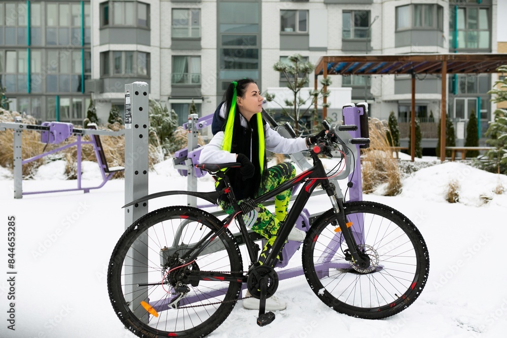 Woman Standing Beside Bike in Snow