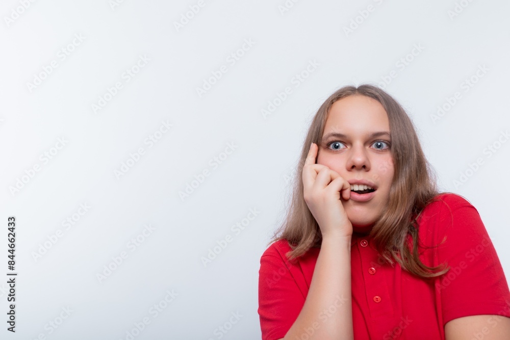 A Caucasian girl with brown hair looks to the side in surprise and attentively A Caucasian girl with brown hair looks to the side in surprise and attentively