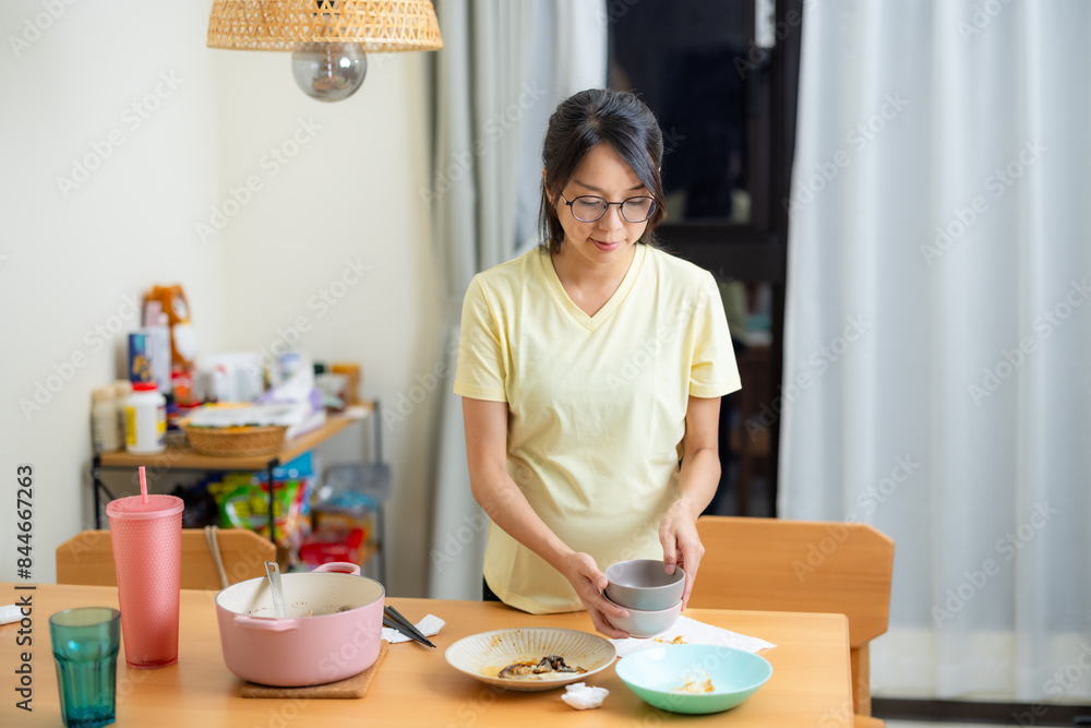 Pregnant woman clean up the dishes after the dinner at home Pregnant woman clean up the dishes after the dinner at home