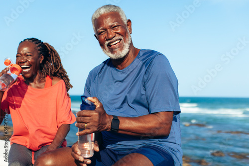 Mature African American couple laughing by the coastal water photo