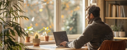 Man working from home, laptop on a minimalist desk, remote work efficiency, copy space for text. photo