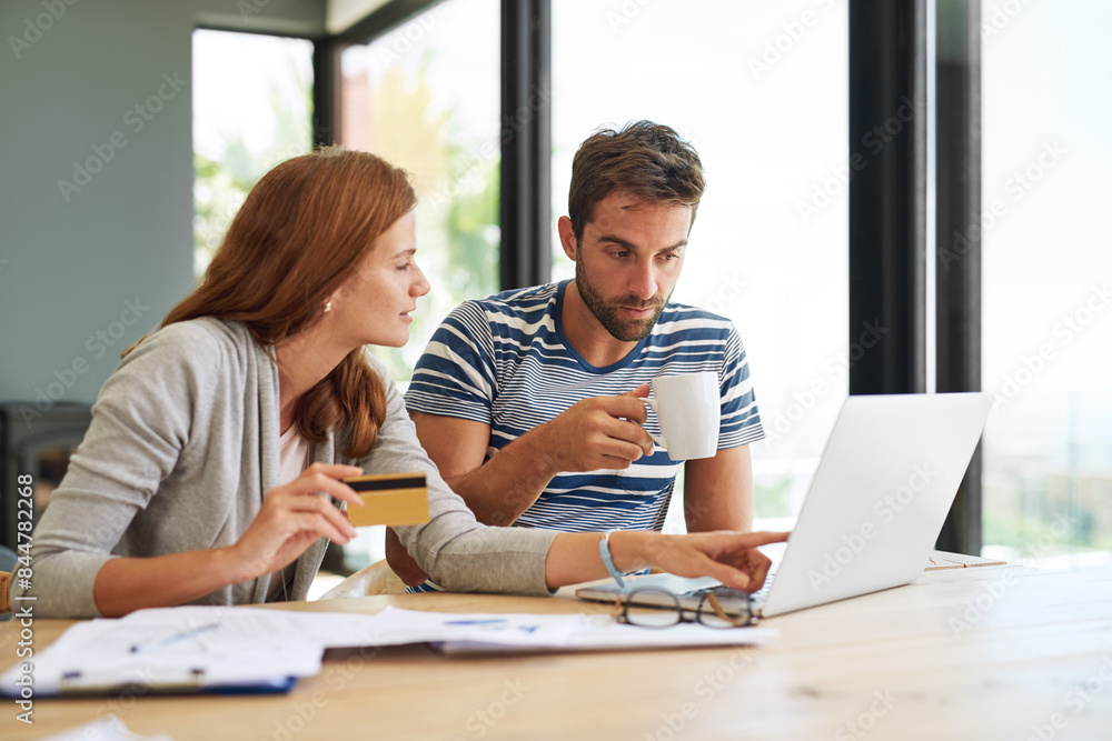 Couple, laptop and credit card at table in morning for online shopping with purchase in house on weekend. Taxes, finance and internet banking with bills or monthly payments for debt in New York. Couple, laptop and credit card at table in morning for online shopping with purchase in house on weekend. Taxes, finance and internet banking with bills or monthly payments for debt in New York.