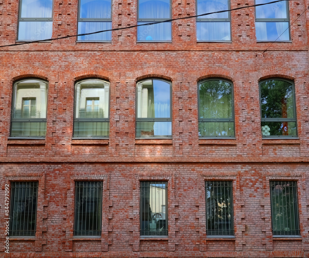 view of facade of historical red brick building arched windows view of facade of historical red brick building arched windows
