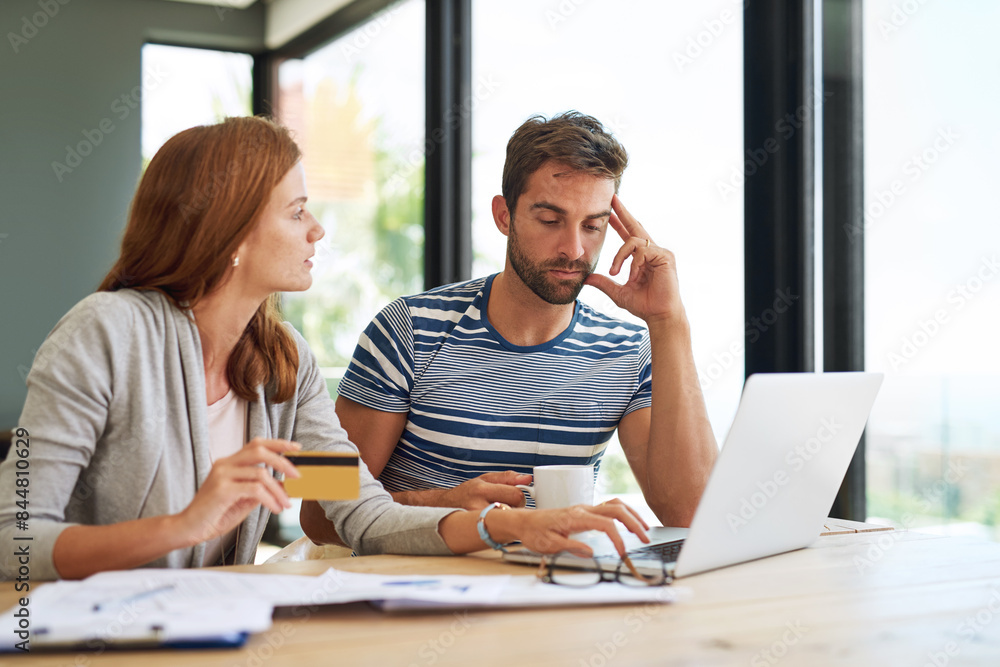 Fototapeta premium Couple, credit card and laptop at table for budget in morning with stress for online payment in house. People, banking and finance with bills, taxes and monthly payments for debt in apartment.