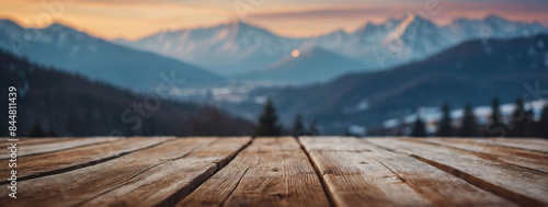 Scenic wooden terrace against a blurred Christmas background. A white tabletop commands attention with a backdrop of soft sky and distant mountain silhouettes. photo