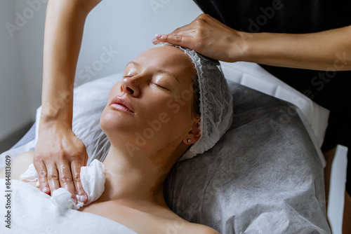 Obraz na plátně Middle aged female receiving facial massage in beauty salon