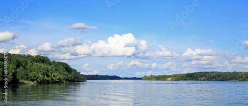 Scenic view of Cruising up the River Danube from Esztergom to Bratislava, with calm water and pale blue cloudy sky