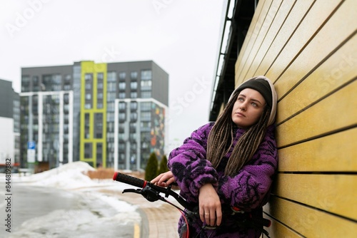 Bicycle rental concept. Young woman with dreadlocks rides a bicycle in the city photo