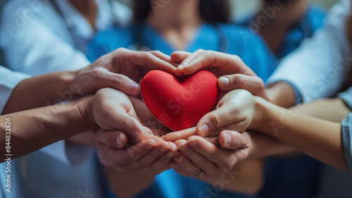A medical team of doctors and nurses hands holding heart symbolize love and care, reflecting the teamwork and dedication of healthcare professionals in improving patient well-being.