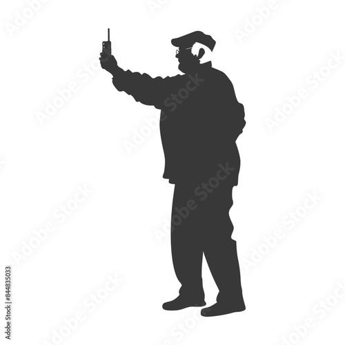 Silhouette of a man with flat cap and headset using radio communication device, isolated.