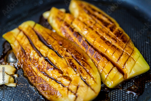 Delicious grilled eggplants with garlic on the fried pan