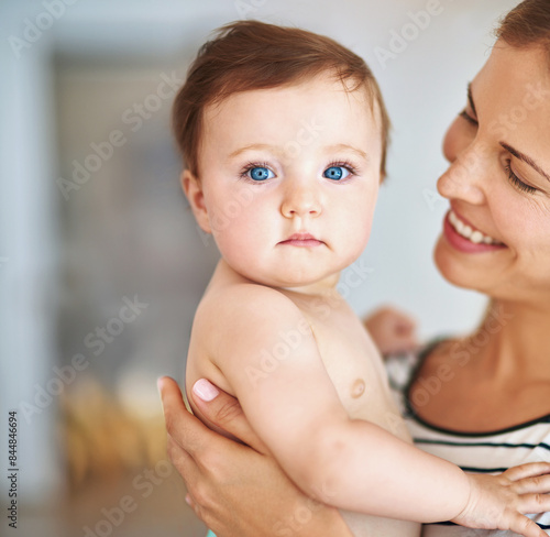 Happy mother, portrait and baby with blue eyes for love, support or childcare at home. Cute or adoable little infant, newborn or young kid with parent, mom or smile in joy or happiness at house photo