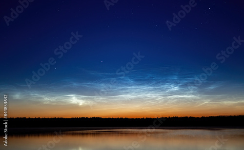 Summer night by the lake with the first noctilucent clouds photo