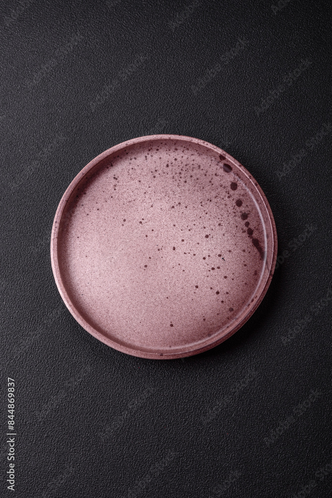 Empty ceramic round plate on dark textured concrete background Empty ceramic round plate on dark textured concrete background