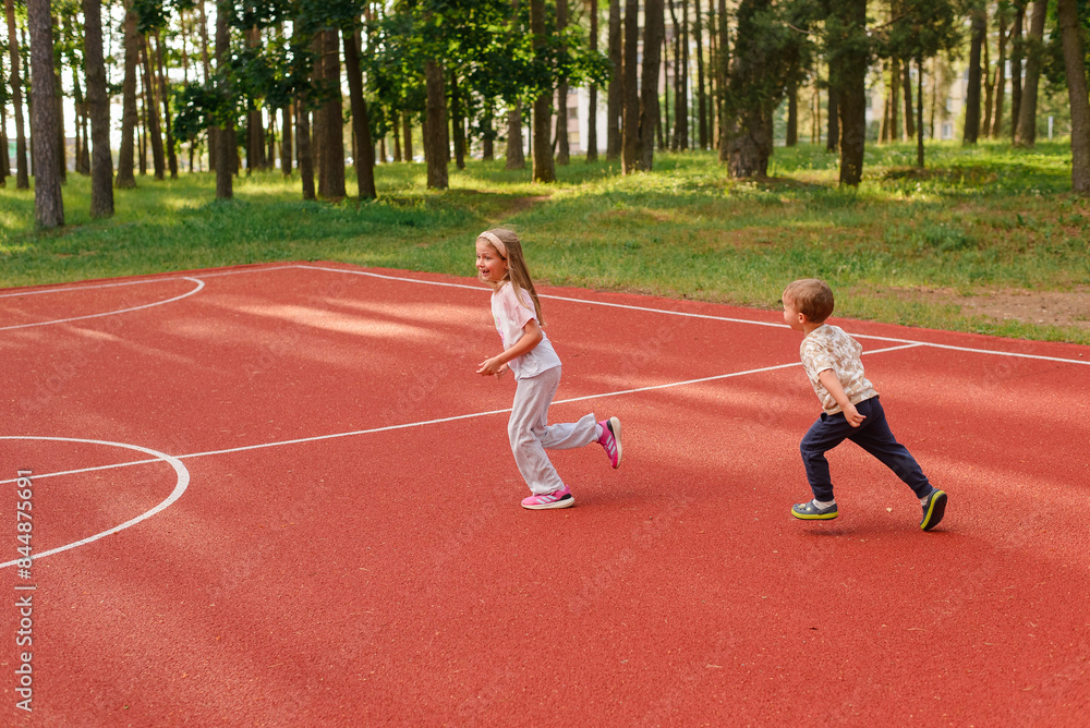 Fototapeta premium little girl and boy running in the park, healthy lifestyle