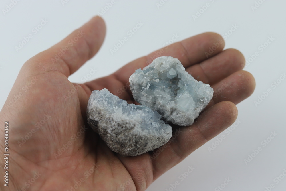 Hand holding two raw celestite geode halves. Hand is holding two raw celestite geode halves, displaying the natural beauty of the crystals. Hand holding two raw celestite geode halves. Hand is holding two raw celestite geode halves, displaying the natural beauty of the crystals.
