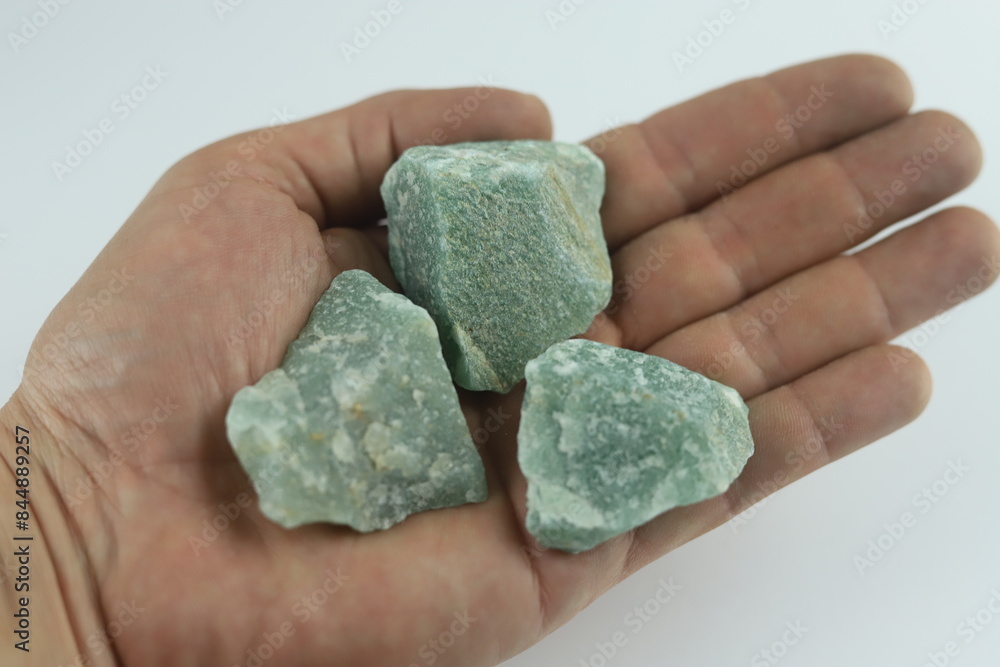 Geologist holding green aventurine crystals in open hand. Geologist is holding three rough green aventurine crystals in the palm of their hand Geologist holding green aventurine crystals in open hand. Geologist is holding three rough green aventurine crystals in the palm of their hand