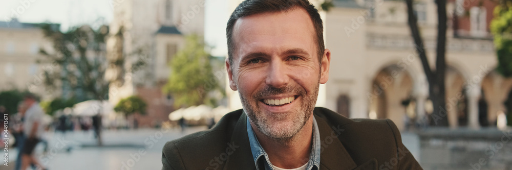 Fototapeta premium Close-up of man looking at the camera and smiling, panorama