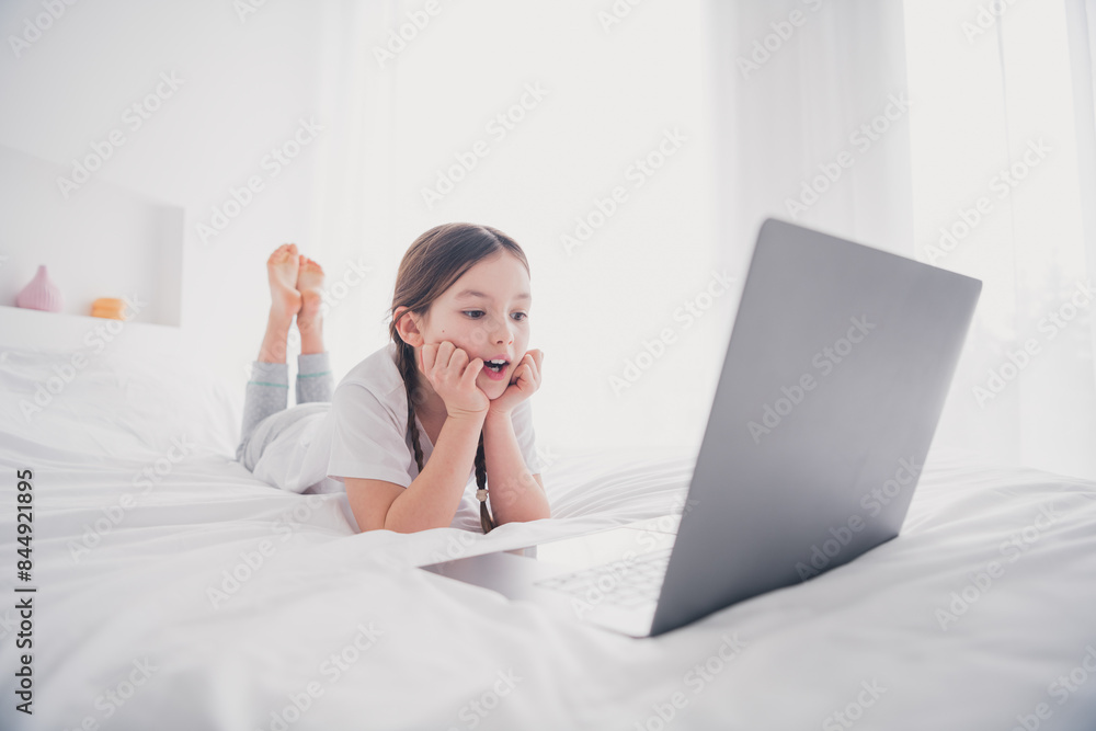 Portrait of cute adorable charming girl enjoying weekend holiday lying bedroom watching video white light room interior indoors Portrait of cute adorable charming girl enjoying weekend holiday lying bedroom watching video white light room interior indoors