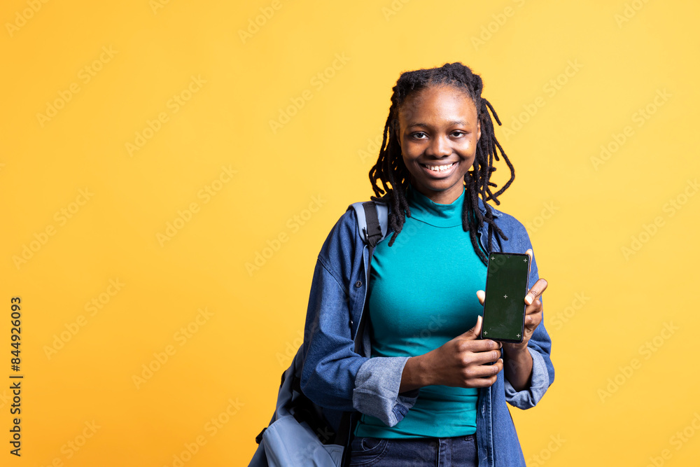Jolly african american woman presenting smartphone with green screen display, isolated over studio background. Joyous BIPOC person creating promotion with blank copy space mockup phone Jolly african american woman presenting smartphone with green screen display, isolated over studio background. Joyous BIPOC person creating promotion with blank copy space mockup phone