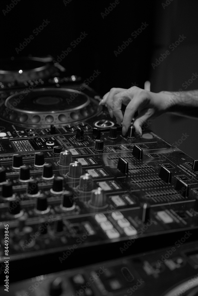 Close-up of a DJ's Hand Adjusting a Mixer Knob in a Professional DJ Console, Captured in Black and White Close-up of a DJ's Hand Adjusting a Mixer Knob in a Professional DJ Console, Captured in Black and White