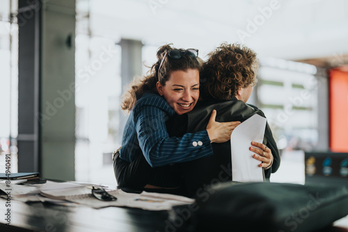 Fotografia Business colleagues embrace warmly in a modern office setting, conveying friendship, team bonding, and supportive work culture