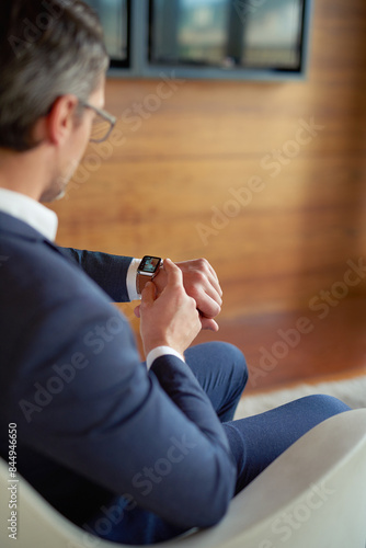 Looking, smart watch or businessman in office for appointment, meeting or notification alert. Check, time management or applicant in waiting room for interview feedback, schedule or accountability
