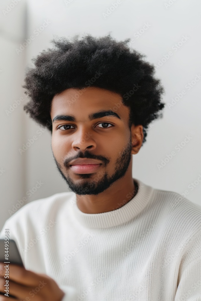 Young man happily using his smartphone indoors, connecting online and enjoying digital activities Young man happily using his smartphone indoors, connecting online and enjoying digital activities