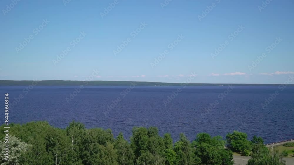 Waves surf on the sea on a sunny day. Blue ocean and sky, water and clouds. Beach, vacation. Romantic coastline landscape.