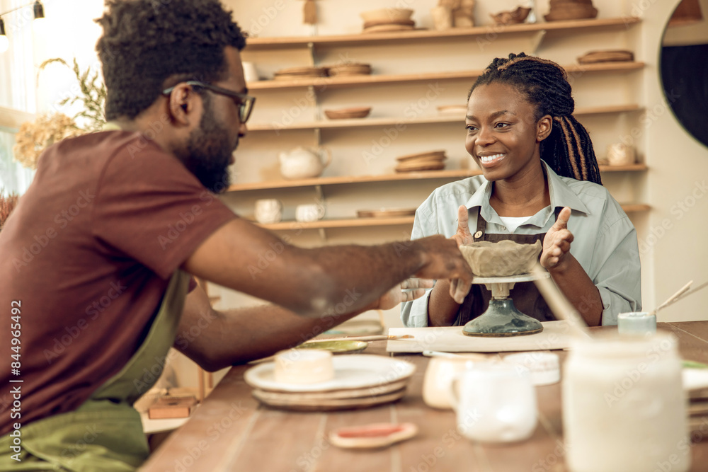 Two people looking involved while working with new pottery Two people looking involved while working with new pottery