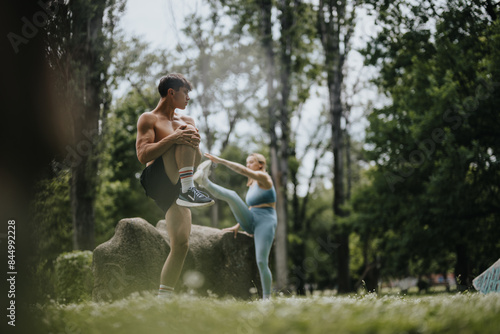 Two young adults engaged in a calisthenics warm-up session outdoors, showcasing fitness and healthy lifestyle.