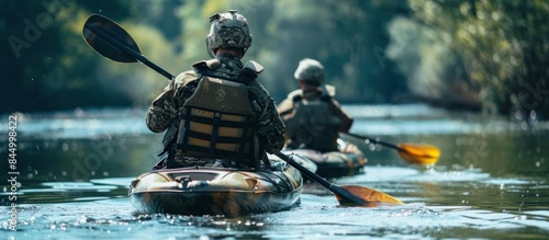 Special forces men with painted faces in camouflage uniforms paddling army kayak. Boat moving across the river, diversionary mission, back view photo