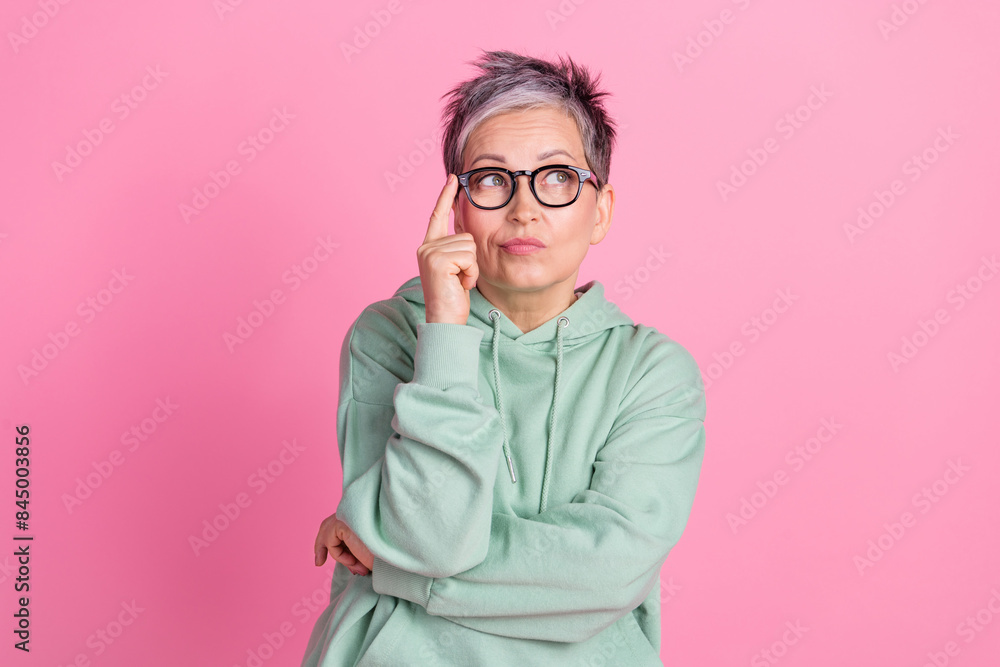 Photo of doubtful cool lady dressed khaki sweatshirt looking empty space isolated pink color background Photo of doubtful cool lady dressed khaki sweatshirt looking empty space isolated pink color background
