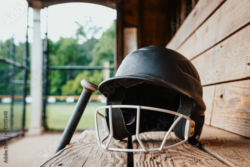 baseball helmet and bat in a dugout bench