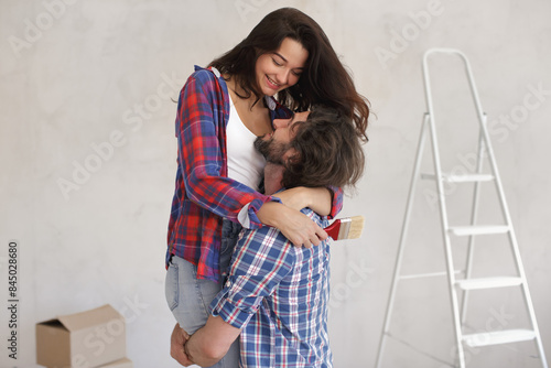 Joyful Couple Embracing with Paintbrush for DIY Home Makeover photo