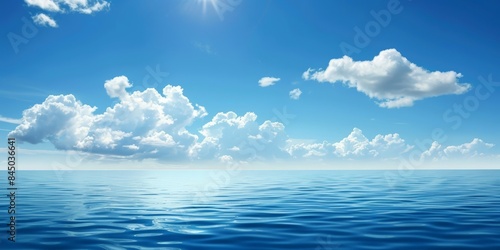 A picture of a clear blue sky with fluffy white clouds over a calm blue ocean