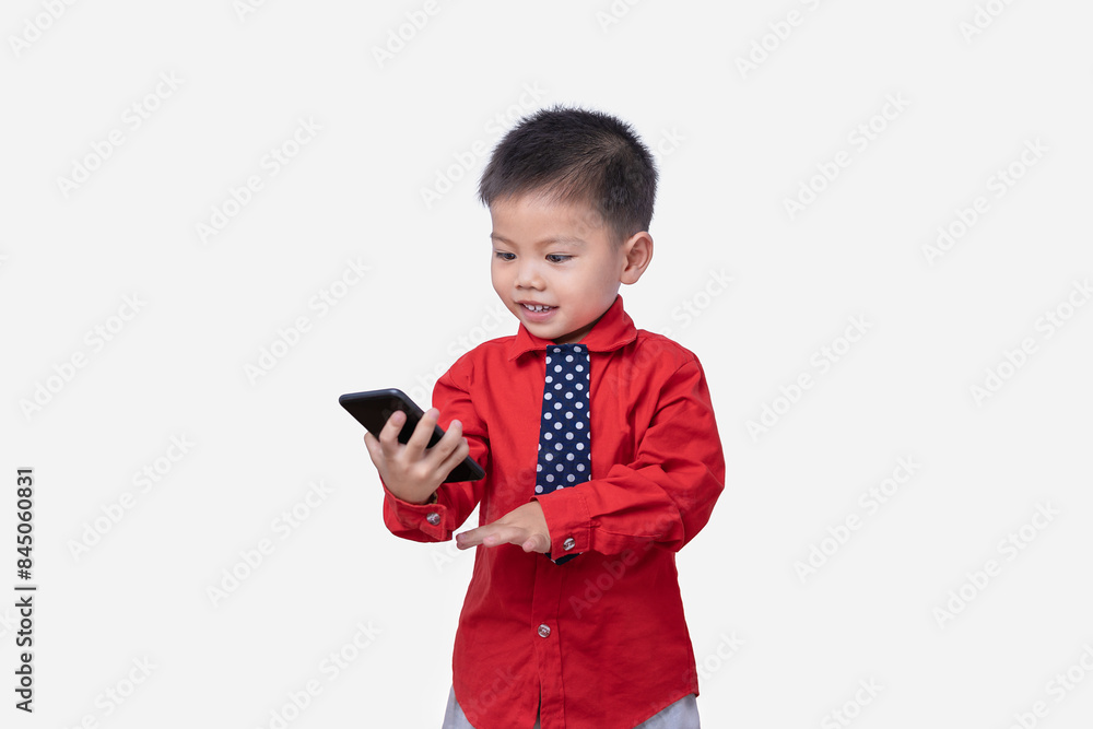 Little small smiling happy boy 3-4 years old wearing a red shirt and holding in hand play smartphone isolated on white background studio portrait. Children and gaming addiction and lifestyle concept Little small smiling happy boy 3-4 years old wearing a red shirt and holding in hand play smartphone isolated on white background studio portrait. Children and gaming addiction and lifestyle concept