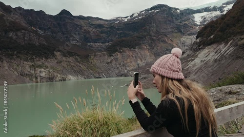 Woman traveler takes pictures of melting glacier Ventisquero Negro. Global warming. Conscious travel photo