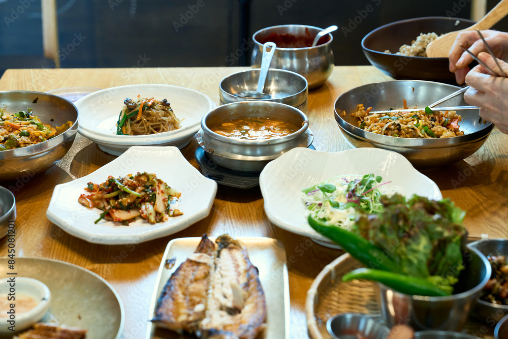 식탁 위에서 반찬과 고등어 구이를 밥과 함께 맛있게 먹고 있는 모습 식탁 위에서 반찬과 고등어 구이를 밥과 함께 맛있게 먹고 있는 모습